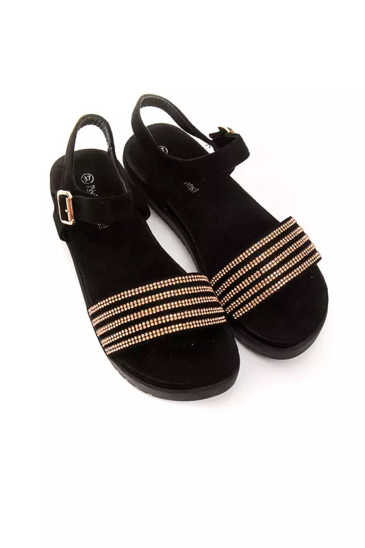 Pair of black suede ankle boots with gold buckles and straps