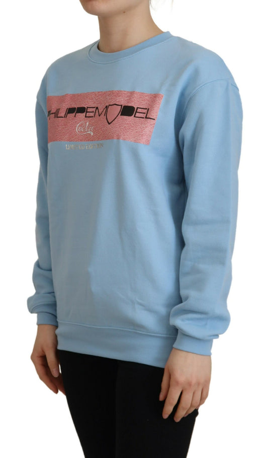 Woman wearing blue sweatshirt with pink design on front