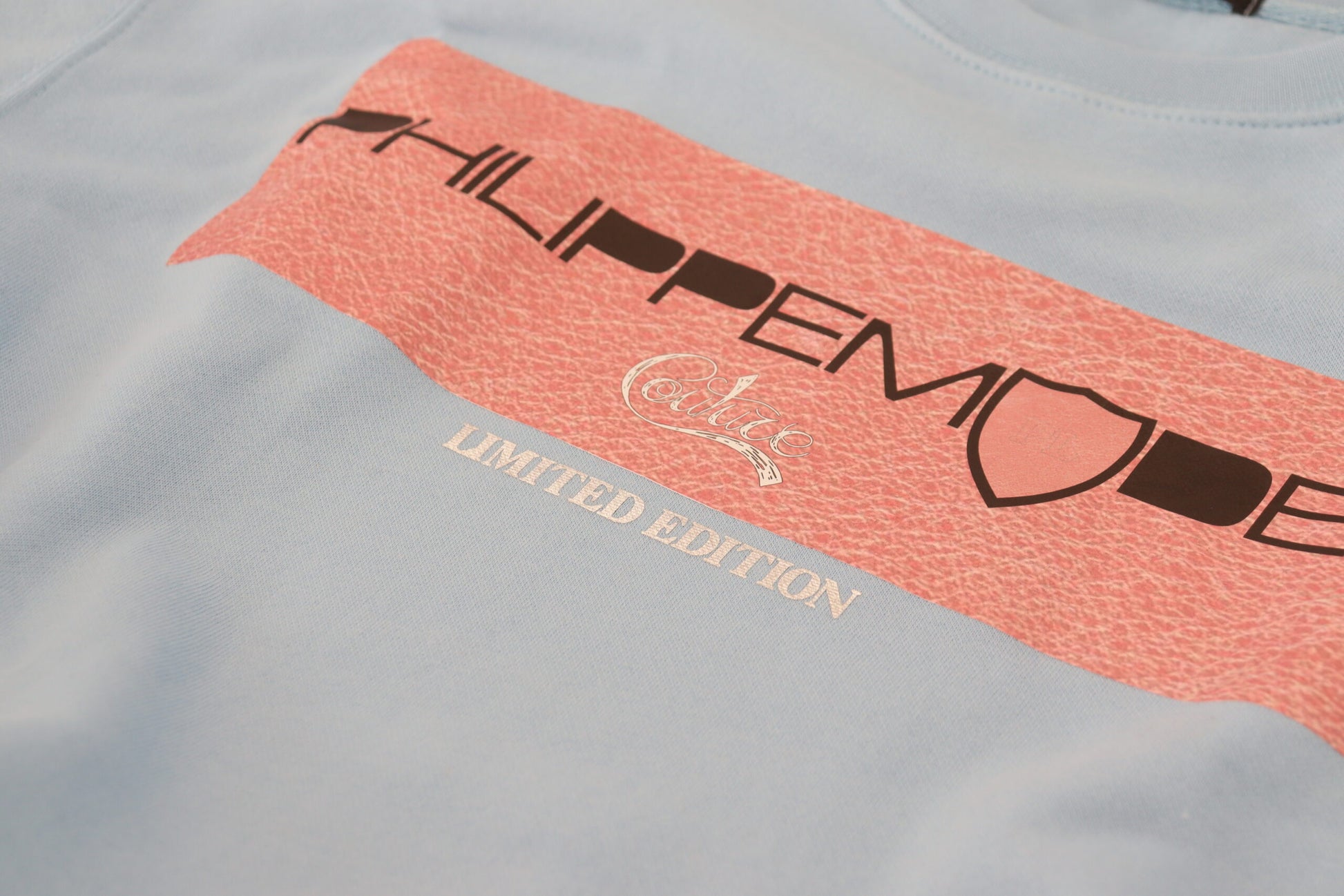 Blue t-shirt with red stripe featuring white text
