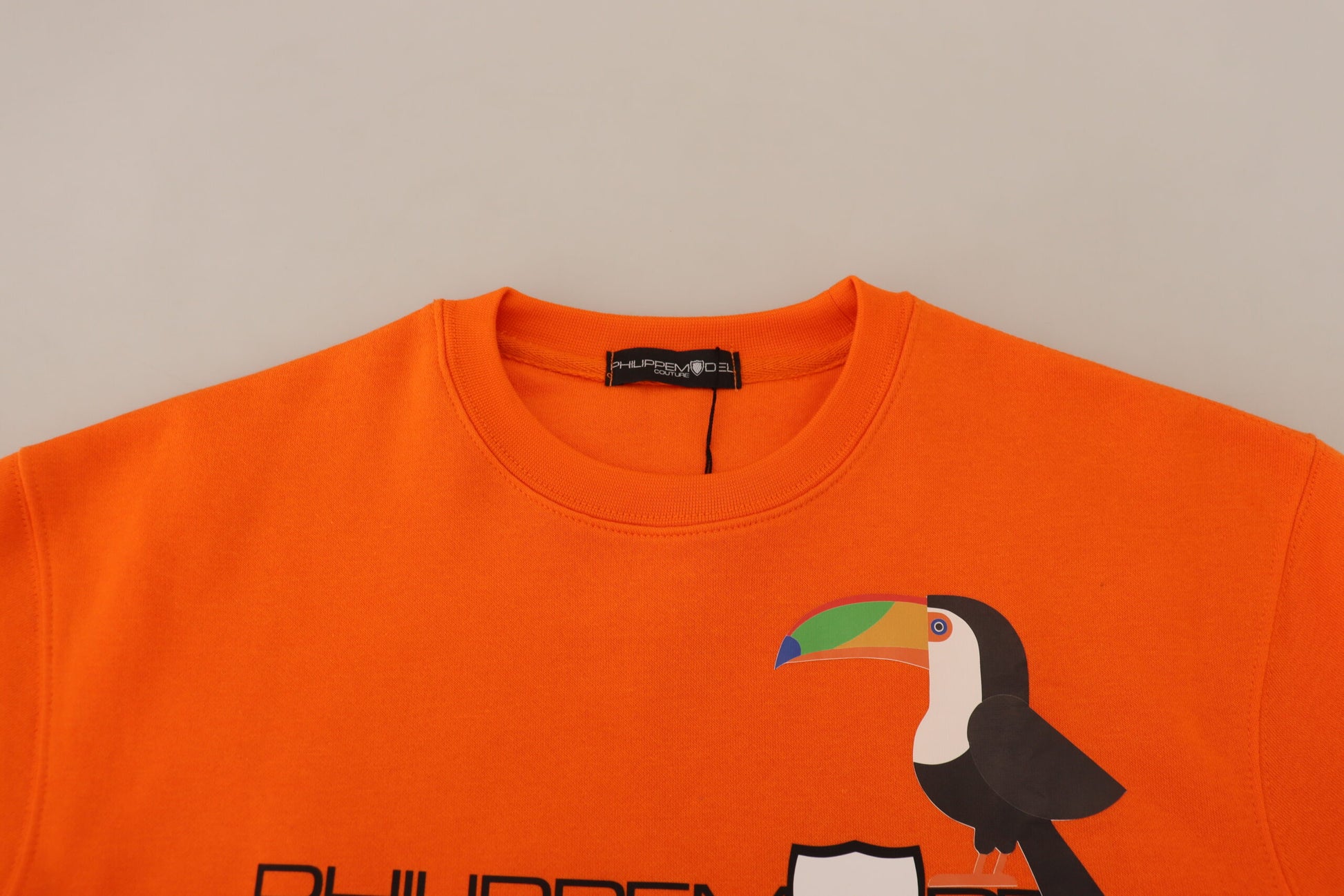 Orange sweater with bird design on front