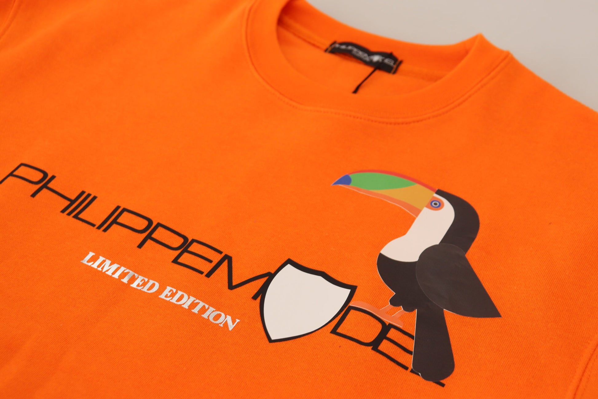 Orange t-shirt with a parrot design on the front