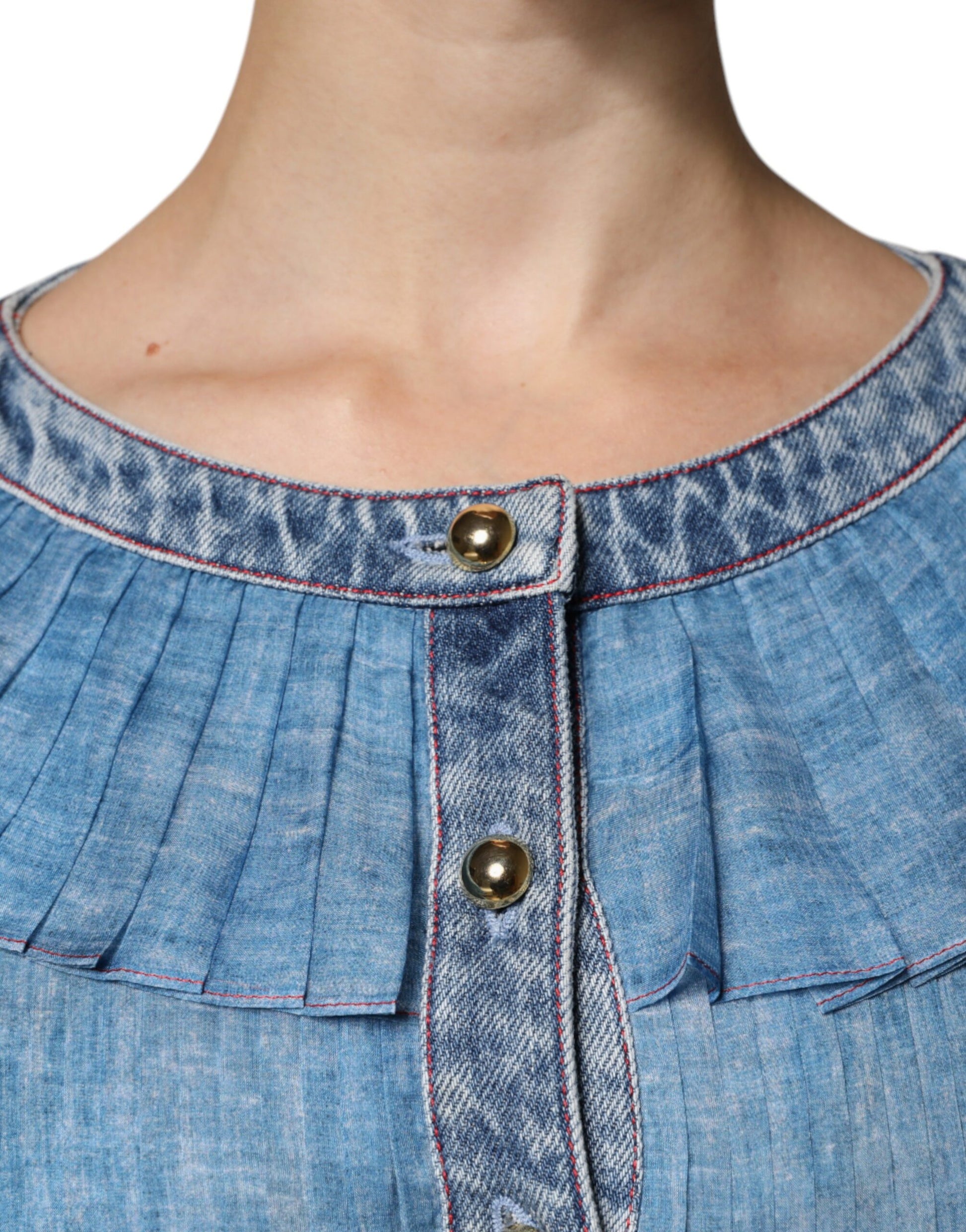 A blue denim dress with a layered design, featuring long sleeves and a button-up front