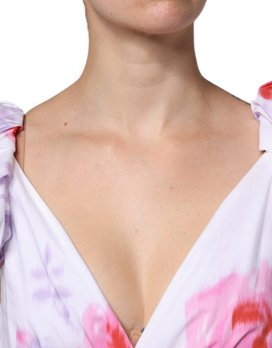 A woman wearing a white floral cotton maxi dress with off-the-shoulder neckline and ruffled sleeves