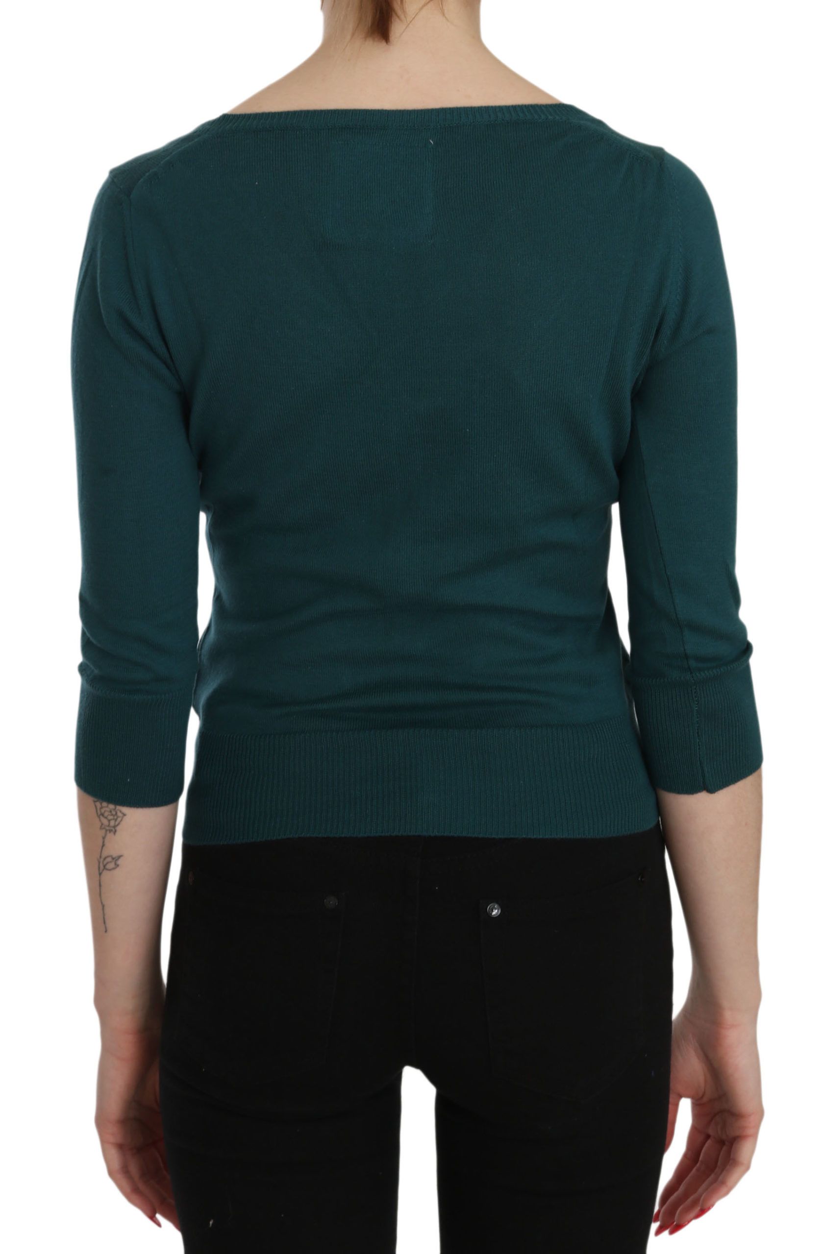 Woman wearing long sleeve green sweater and black pants