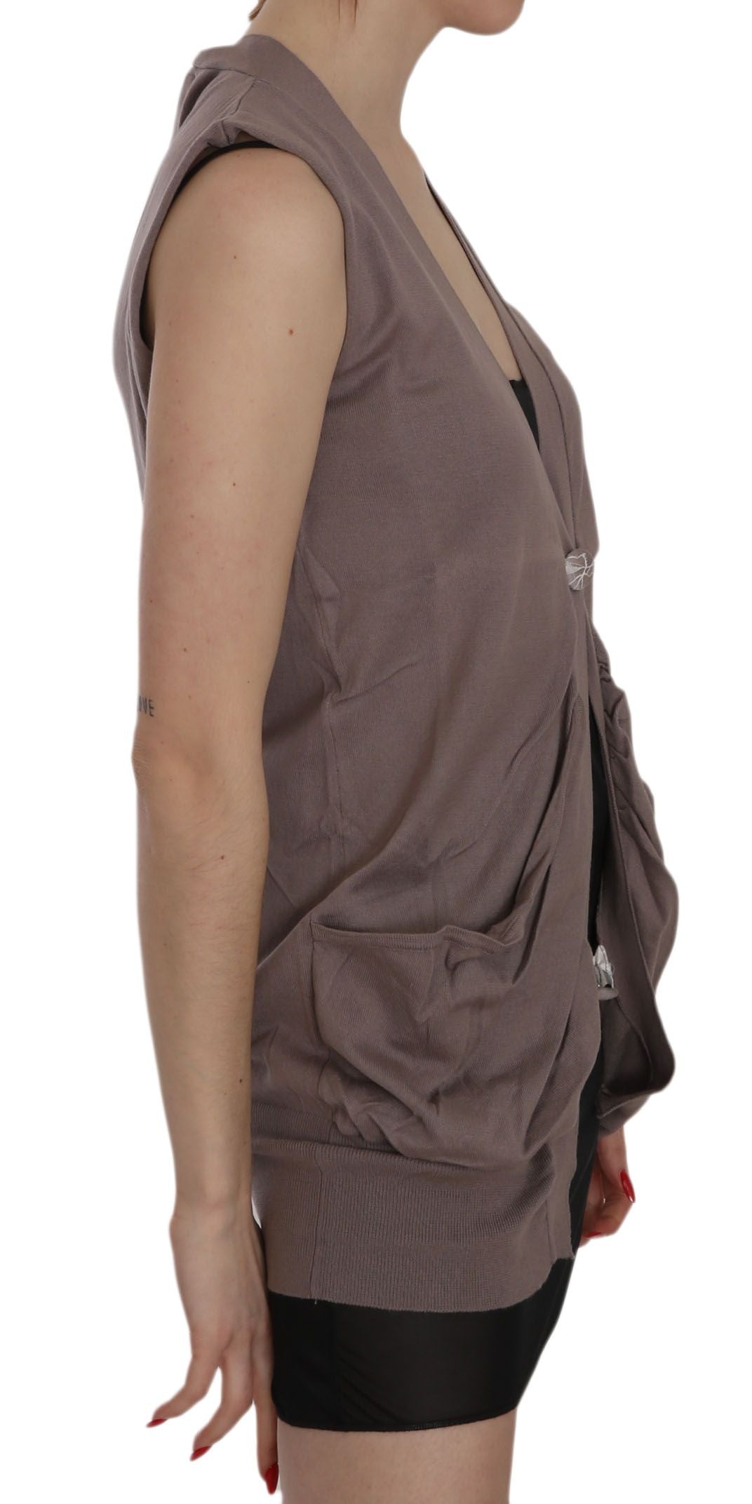 Woman wearing a gray vest over a black top