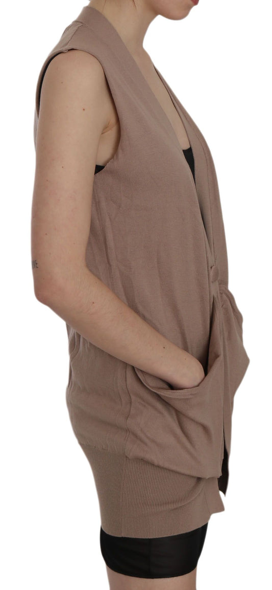 Woman wearing a beige cardigan vest over a black top