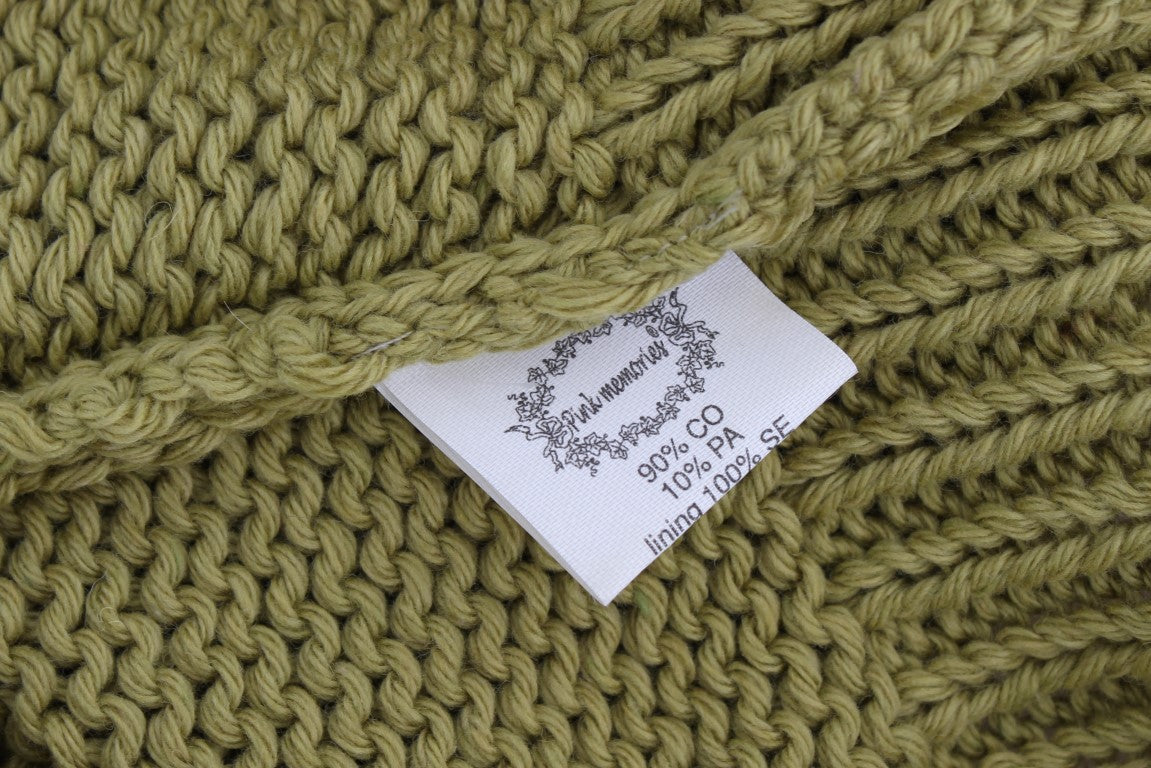 Green knitted fabric with a tag attached to it
