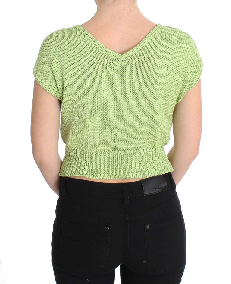 Woman wearing green knit top and black pants