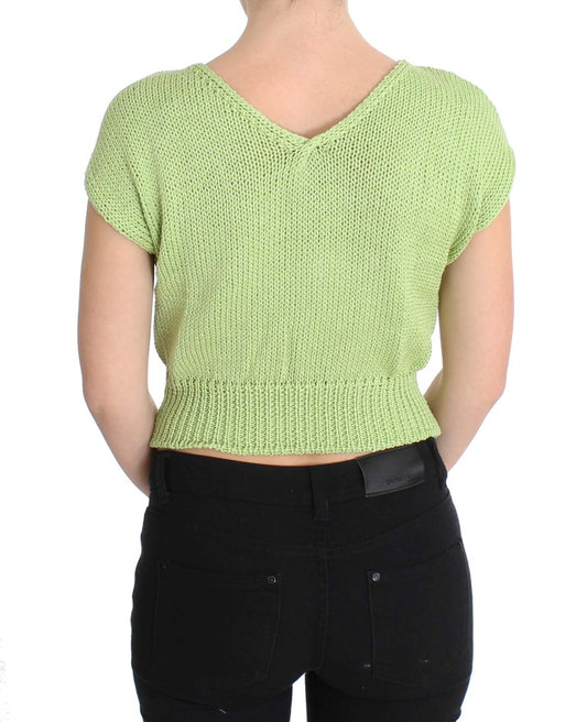 Woman wearing green knit top and black pants