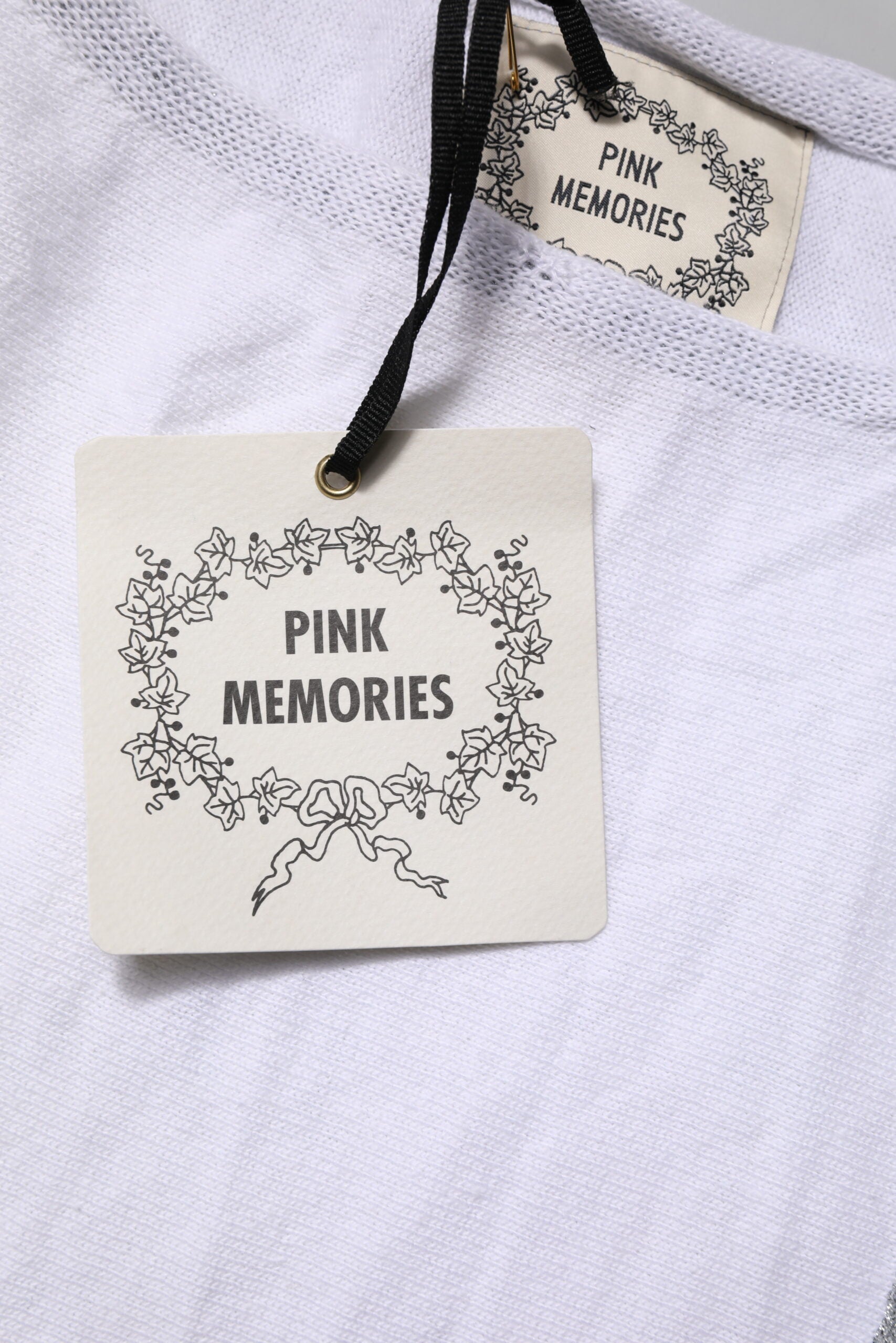 White t-shirt with black tag attached to neckline