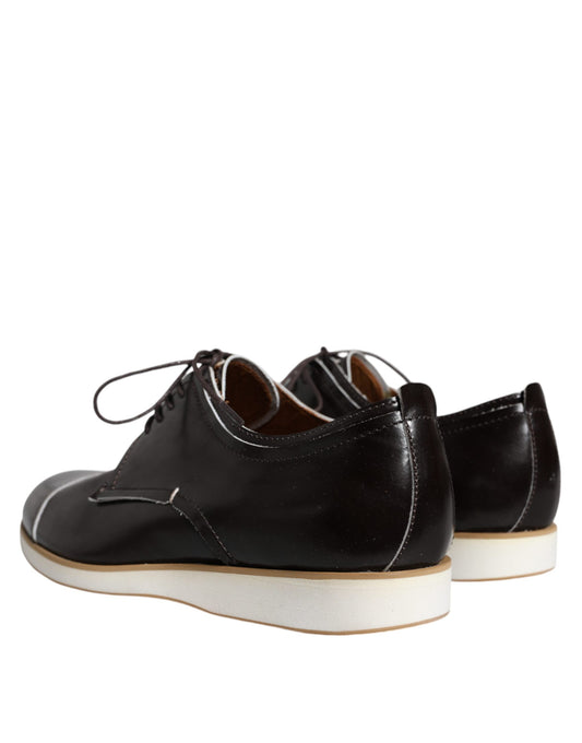 Pair of black lace-up shoes with white sole, featuring a leather upper and a classic design