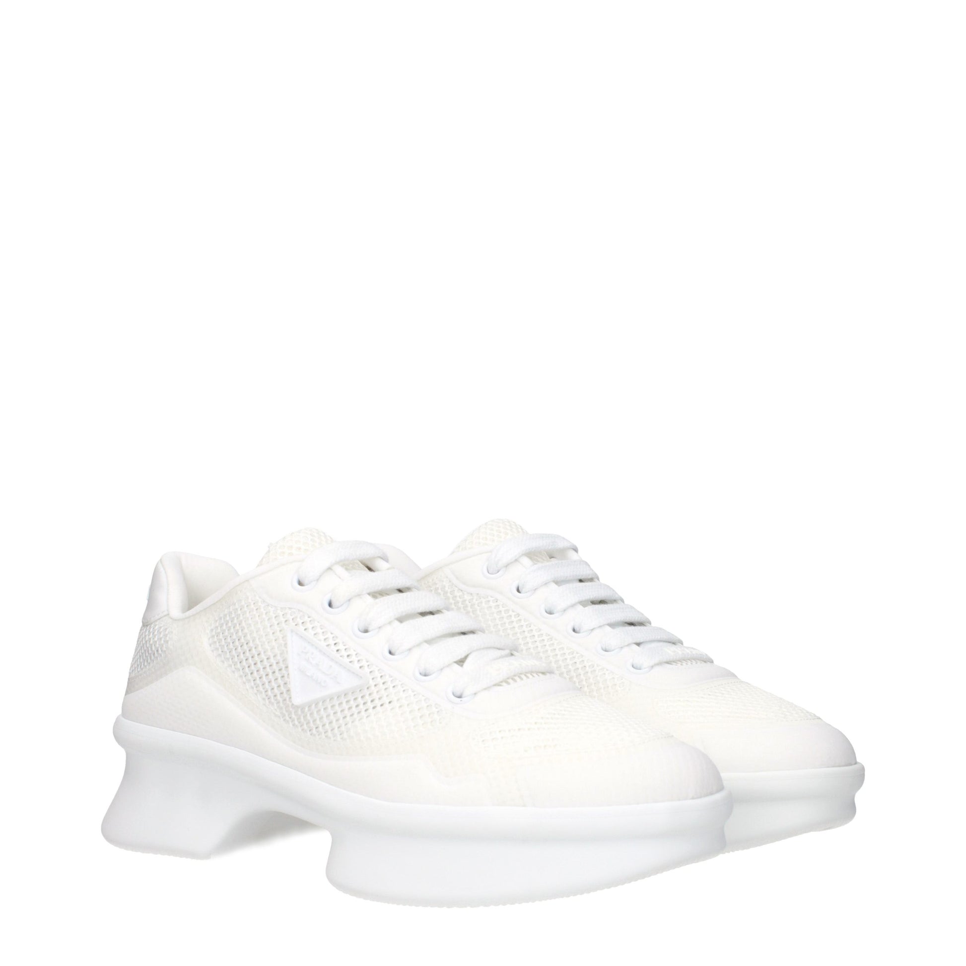 Pair of white athletic sneakers with laces, featuring a textured fabric upper and a flat sole design