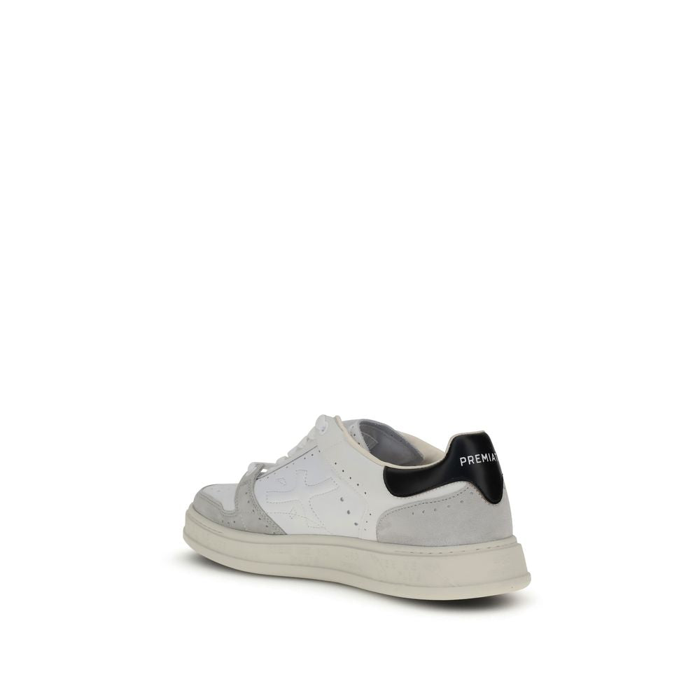 A pair of white calf leather sneakers with black laces and a low top design