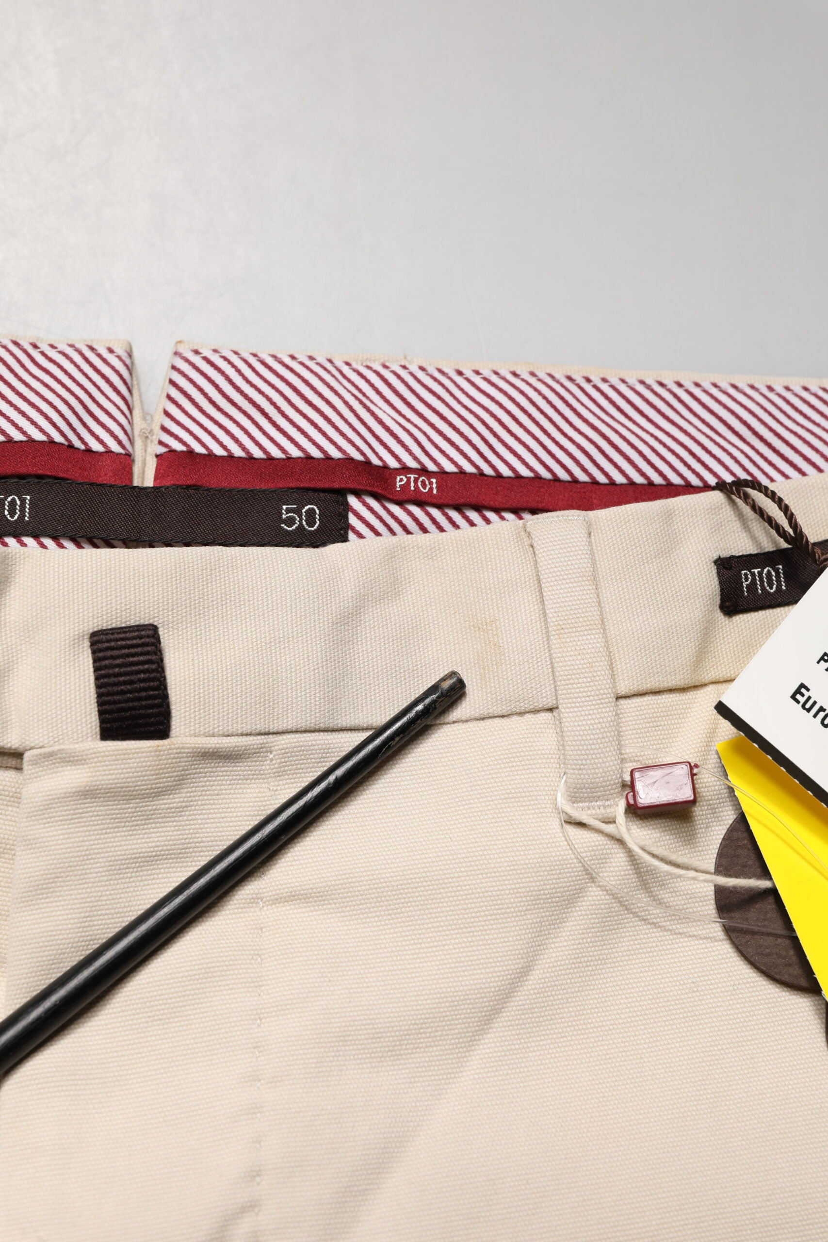 Tan men's chino pants with black belt loops and a zipper fly