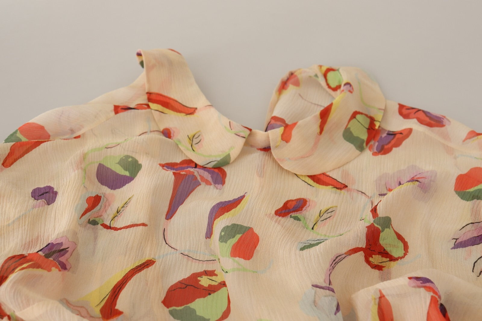 A red, beige, and purple floral patterned mini dress with short sleeves