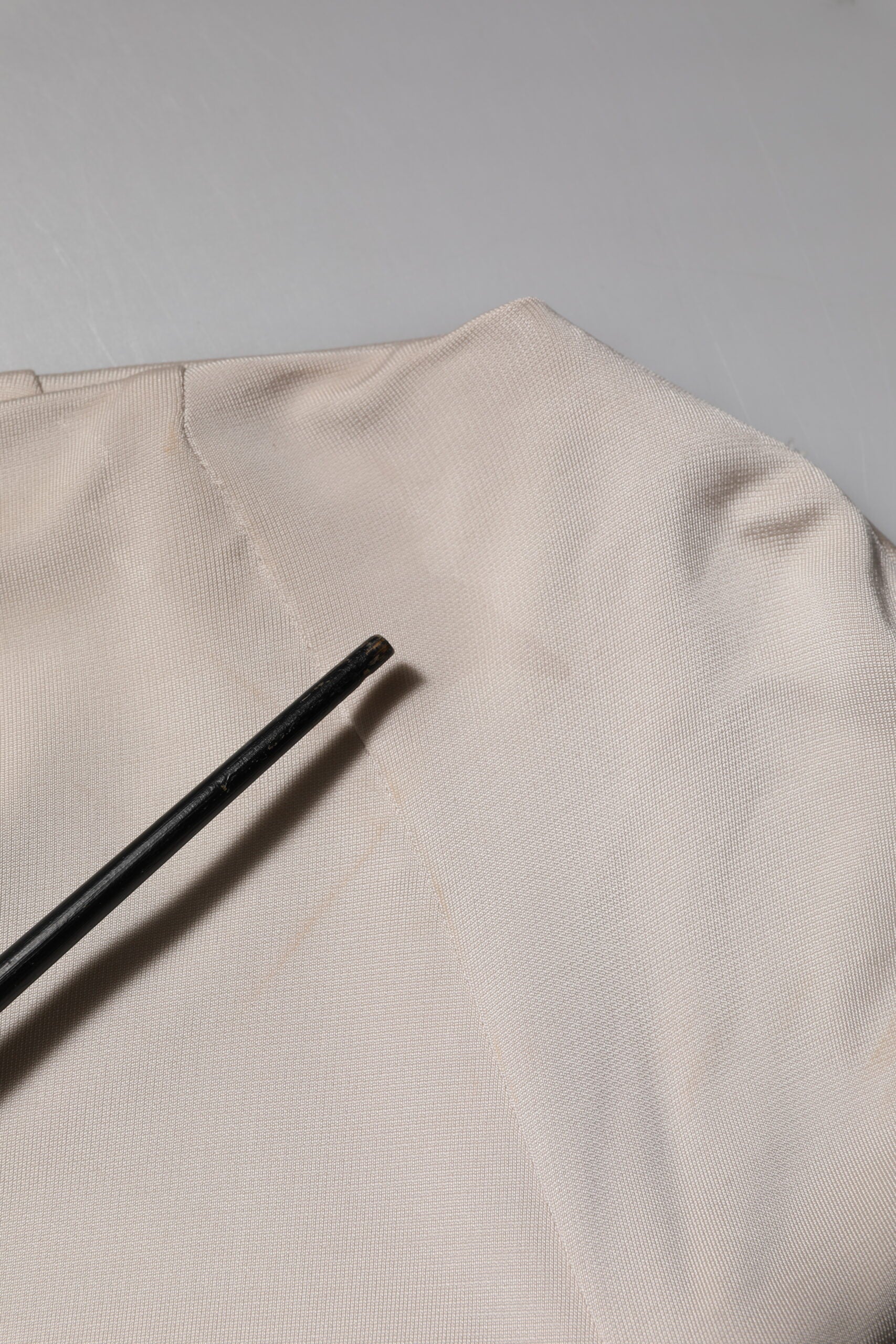 A knee-length dress made of ivory viscose fabric with a textured pattern