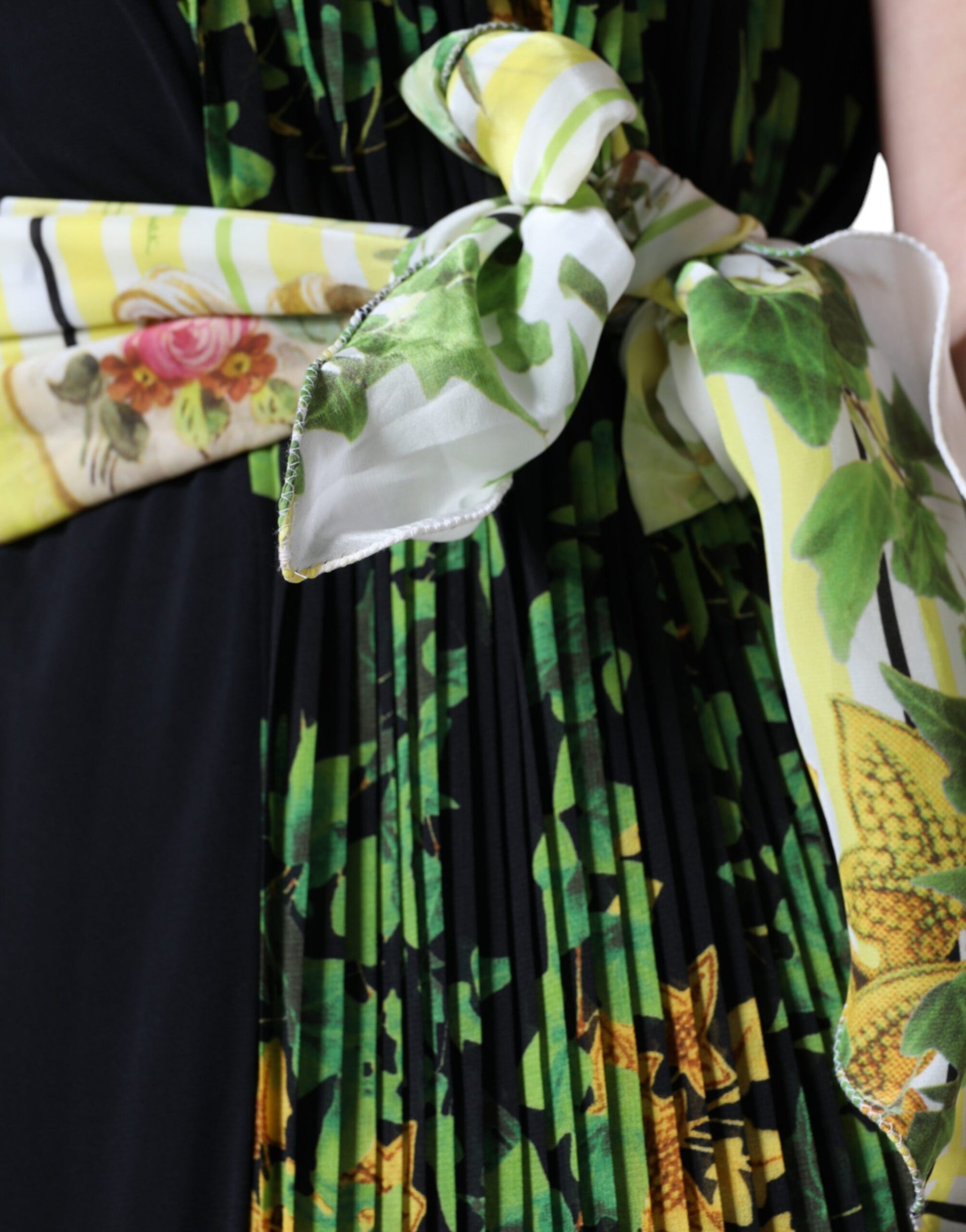 A knee length dress with a floral pattern, featuring a tie at the waist and sleeves