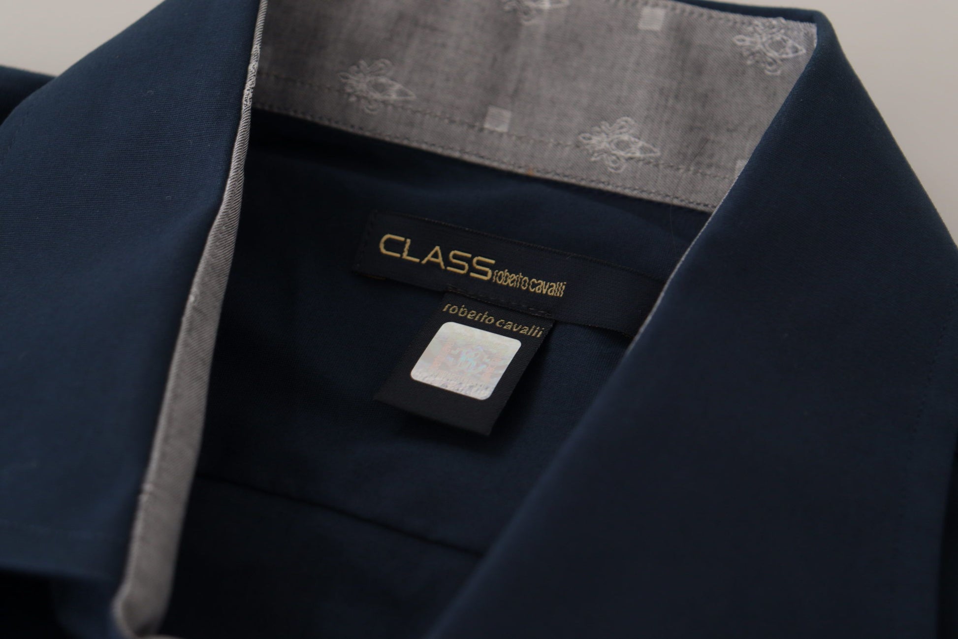 A navy blue dress shirt with a gold label on the front