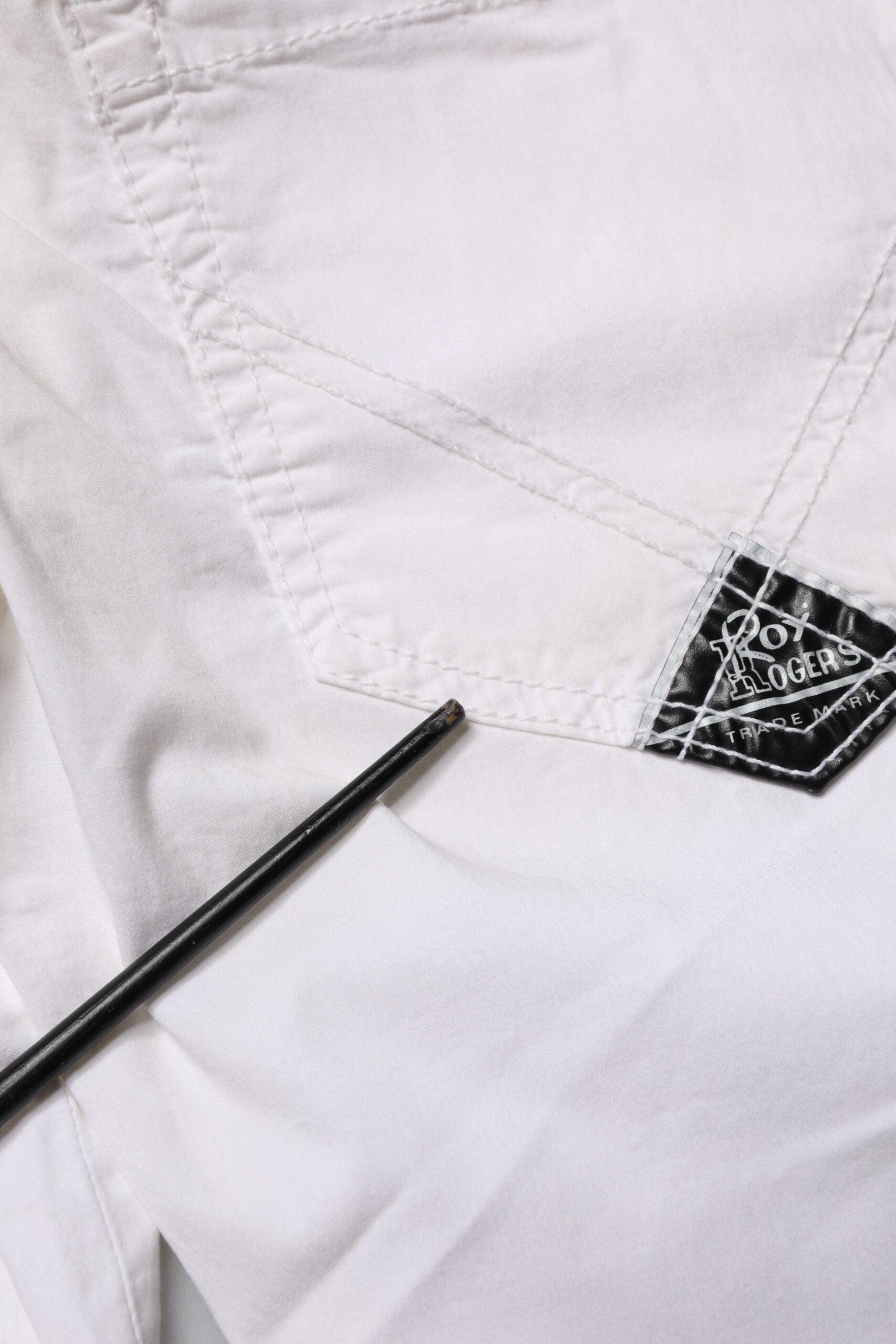 Pair of white pants with black label on pocket