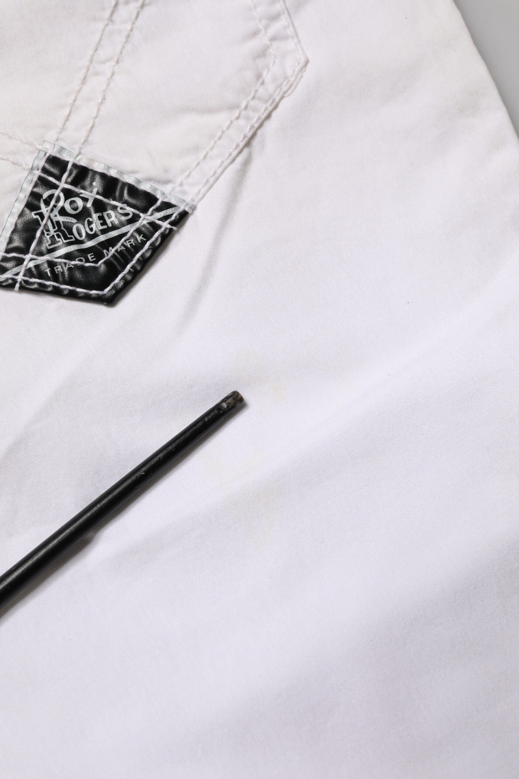 White shirt with black emblem on left chest