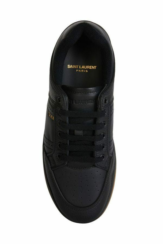 Black sneaker with yellow logo on side and sole