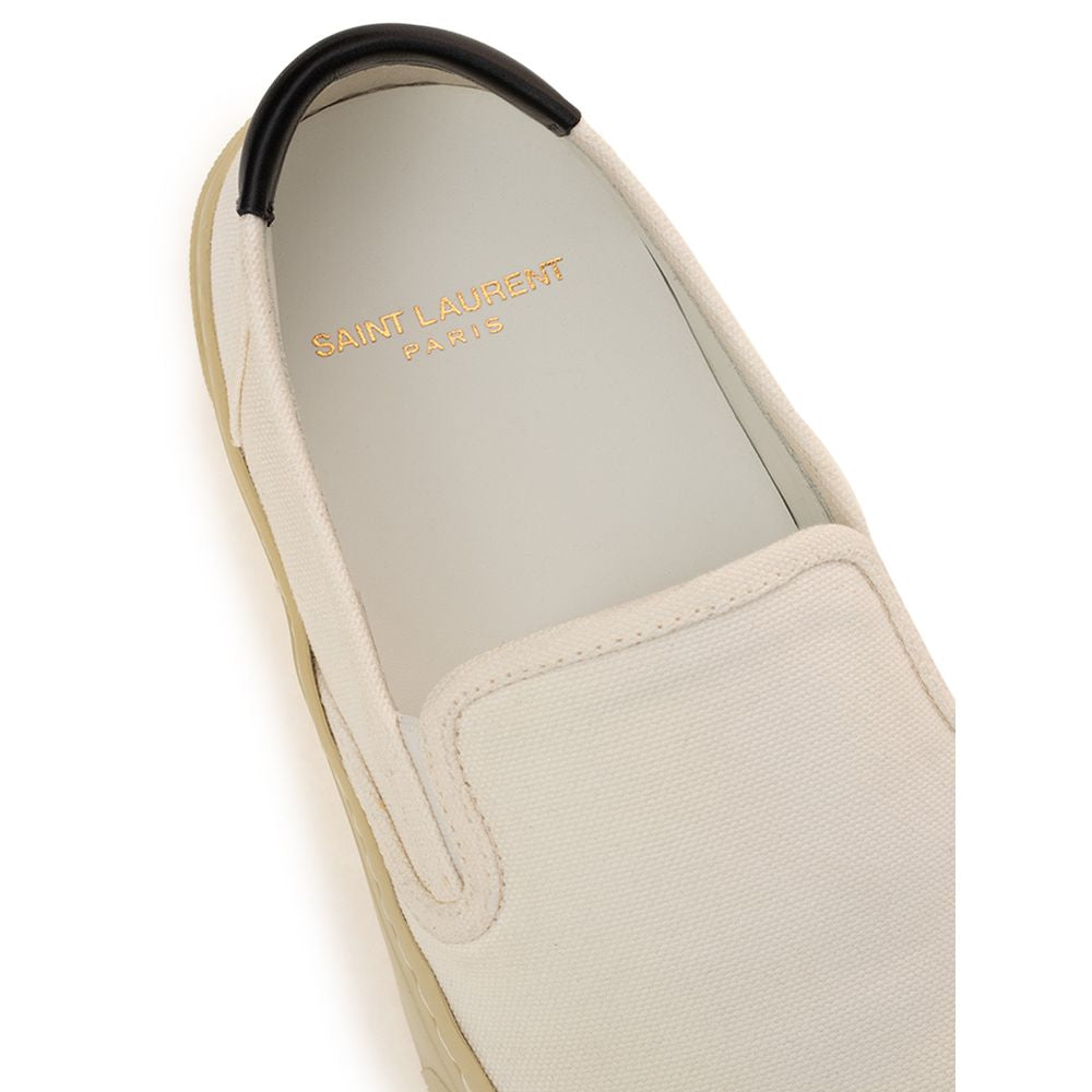 Tan slip on shoe with black sole and gold branding