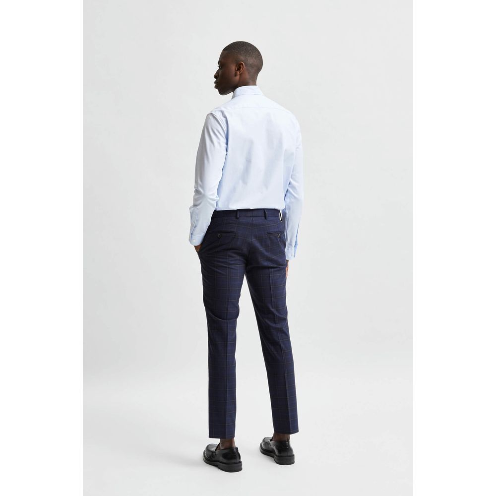 A mannequin wearing a blue dress shirt with rolled-up pants, standing against a white background