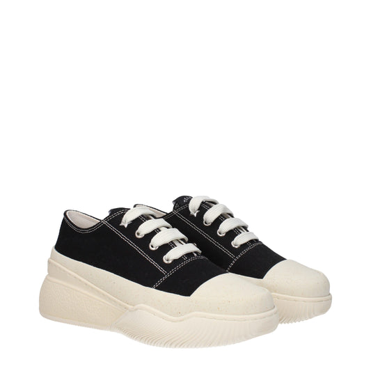 Pair of black chunky sneakers with white laces, featuring a textured sole and a contrasting beige toe cap