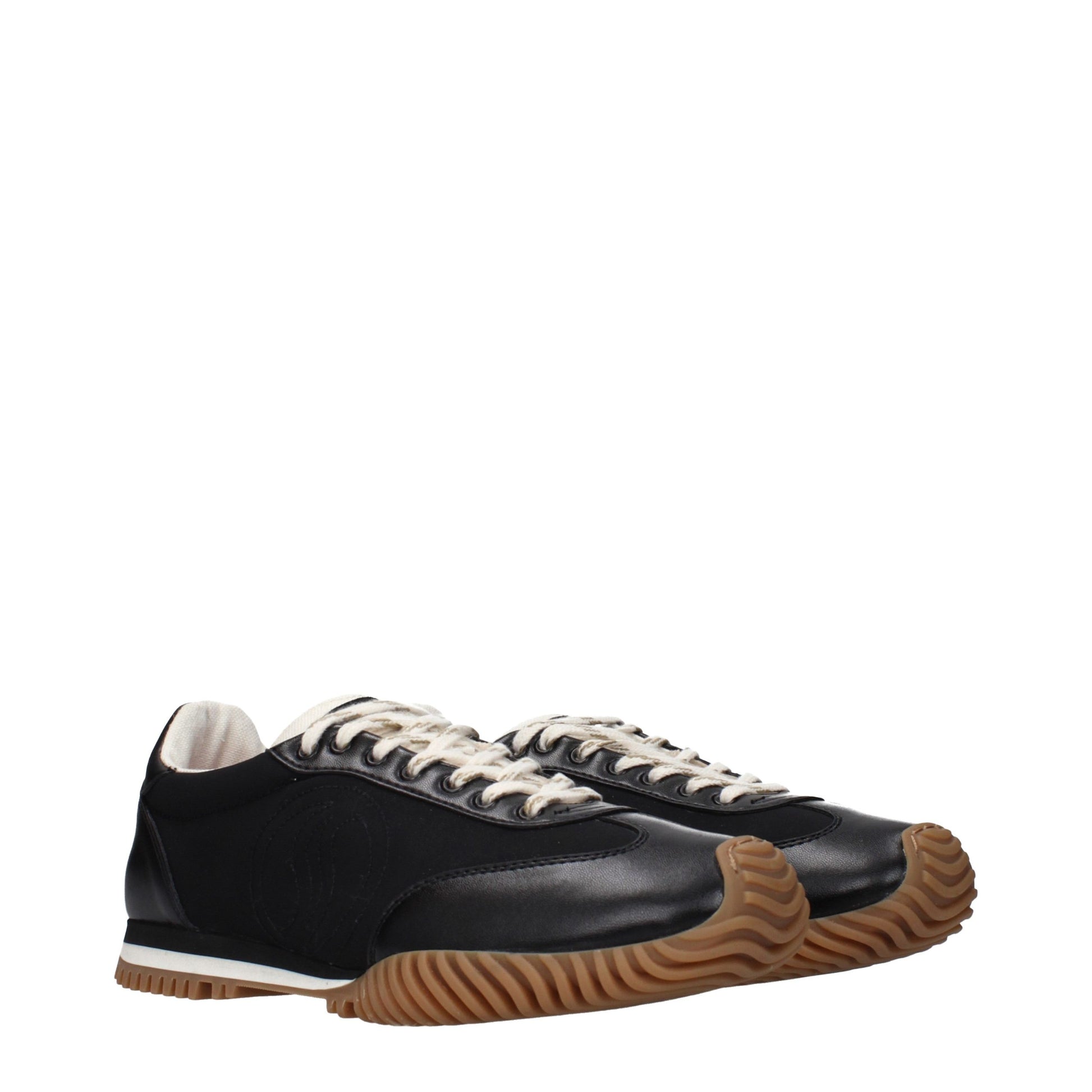A pair of black sneakers with white laces, featuring a textured sole and a low top design