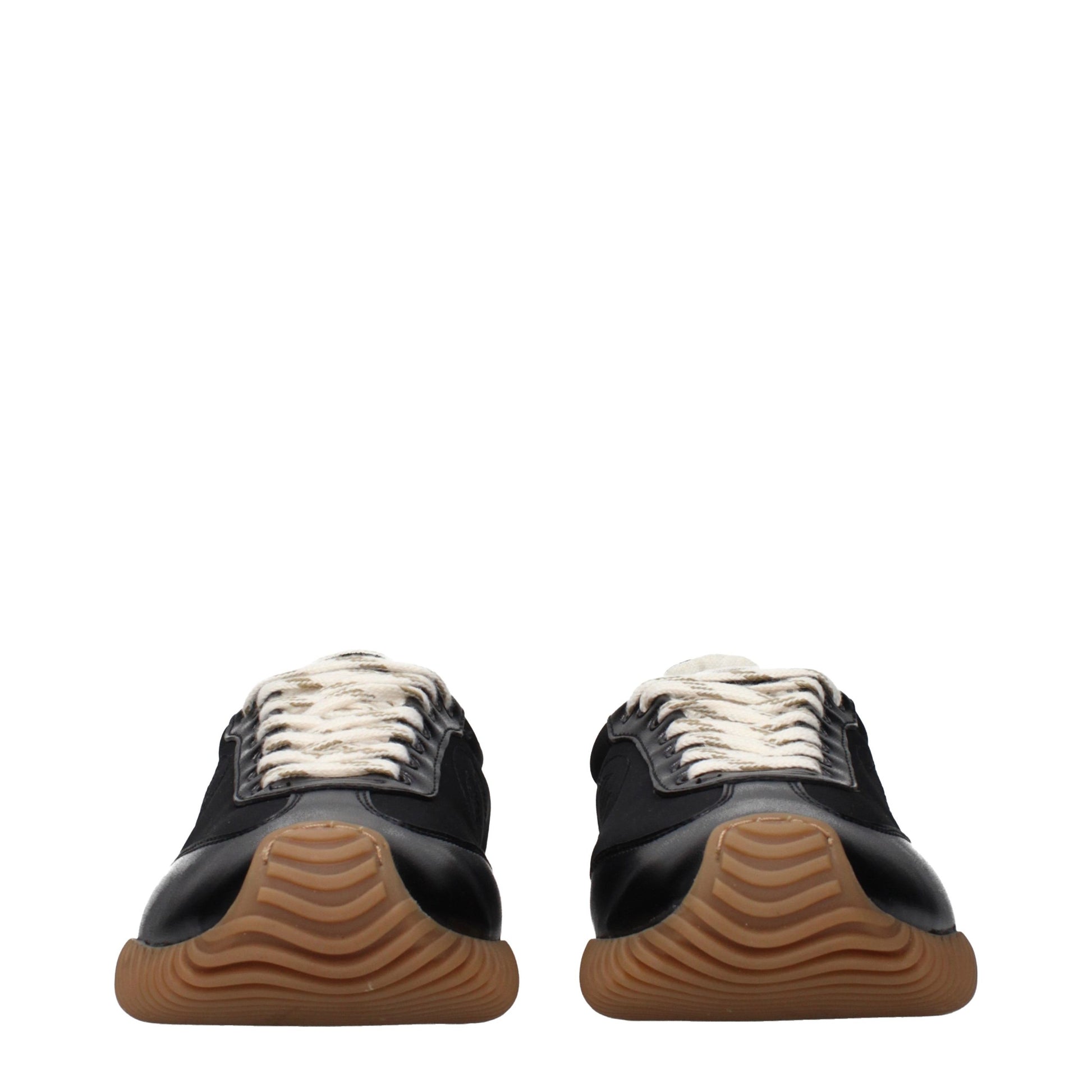 Pair of black sneakers with white laces, featuring a textured sole and a low top design