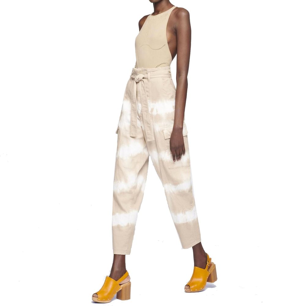 Woman wearing beige jumpsuit with tie at waist and yellow heels