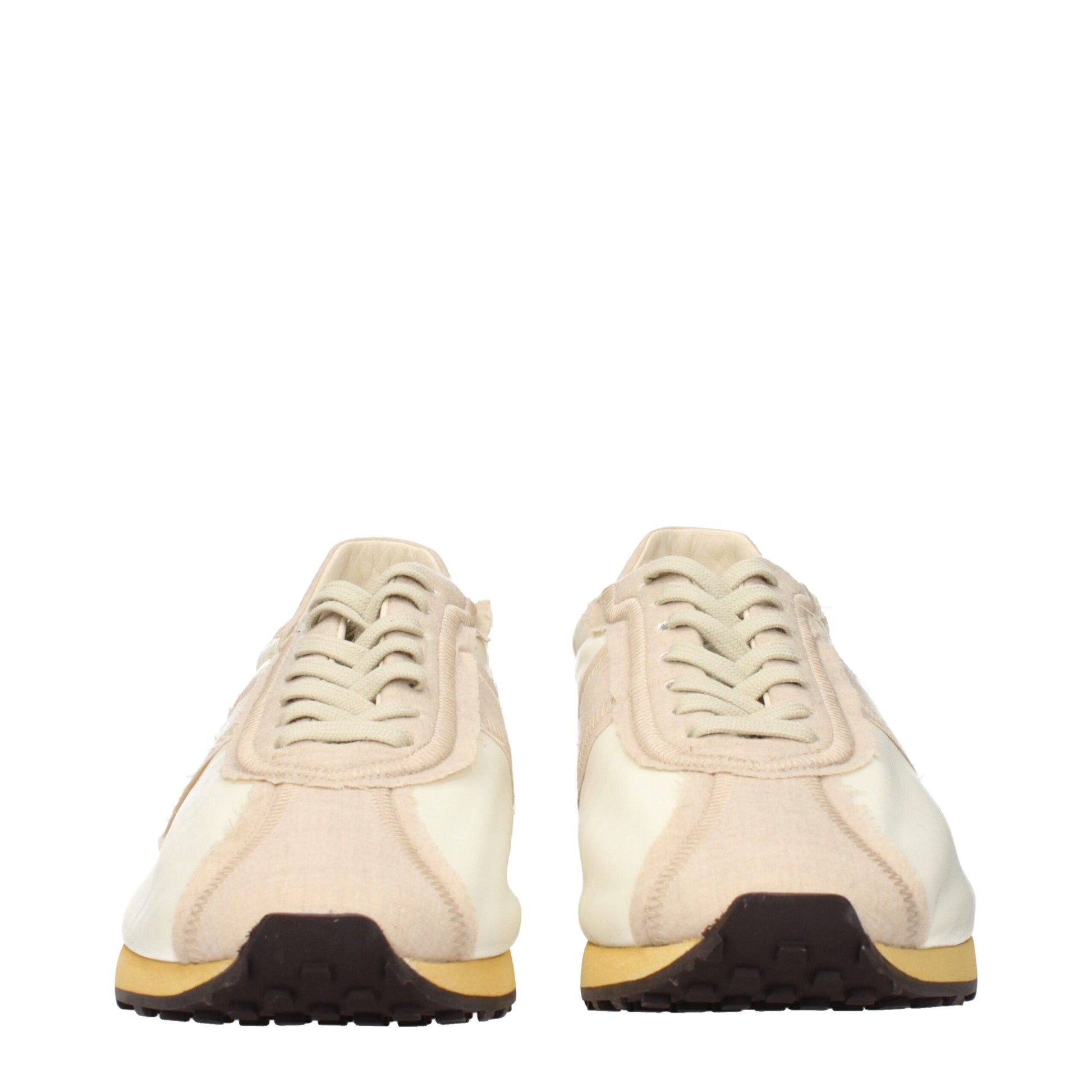 Pair of beige fabric athletic sneakers with black laces, white soles and yellow accents