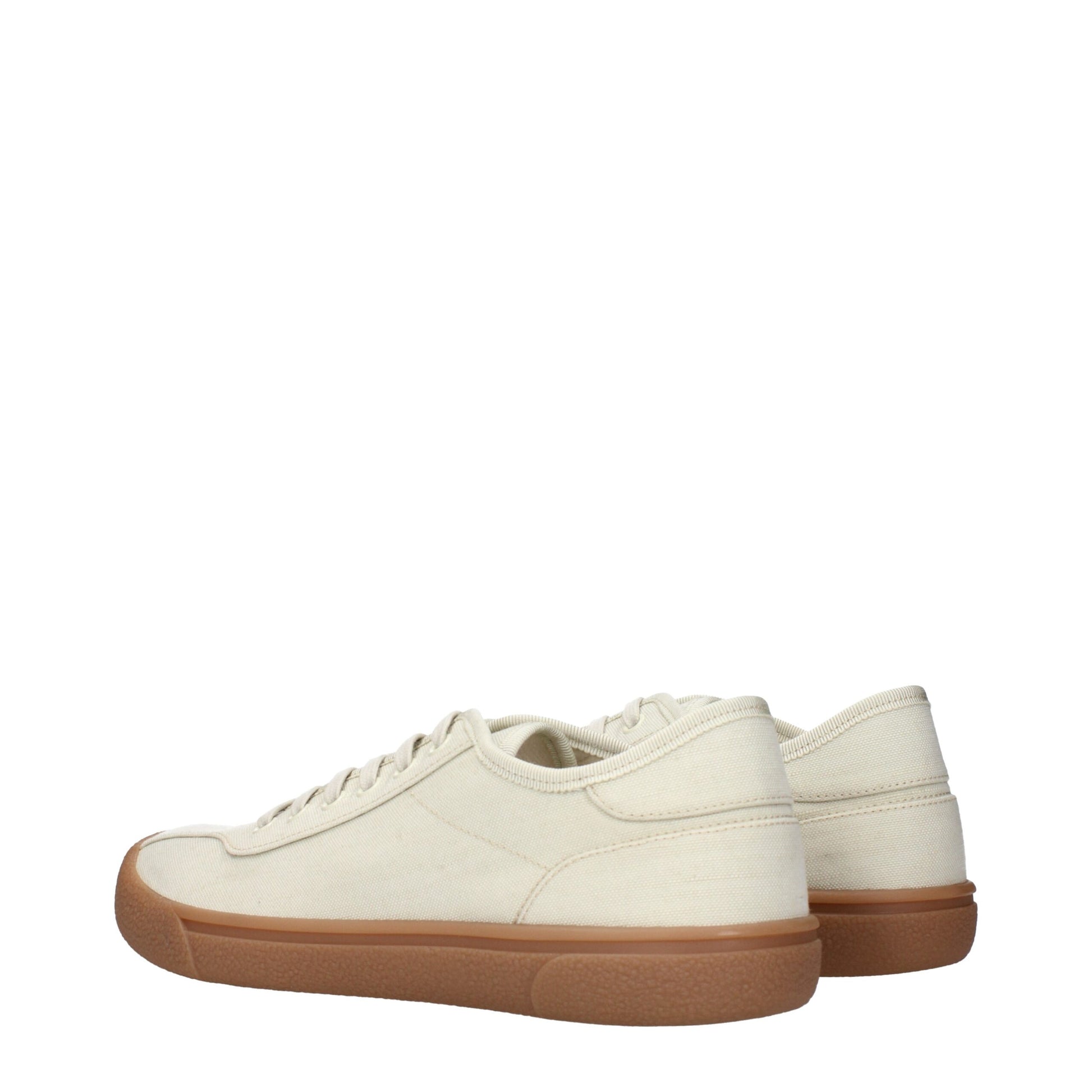 A pair of beige fabric sneakers with brown soles
