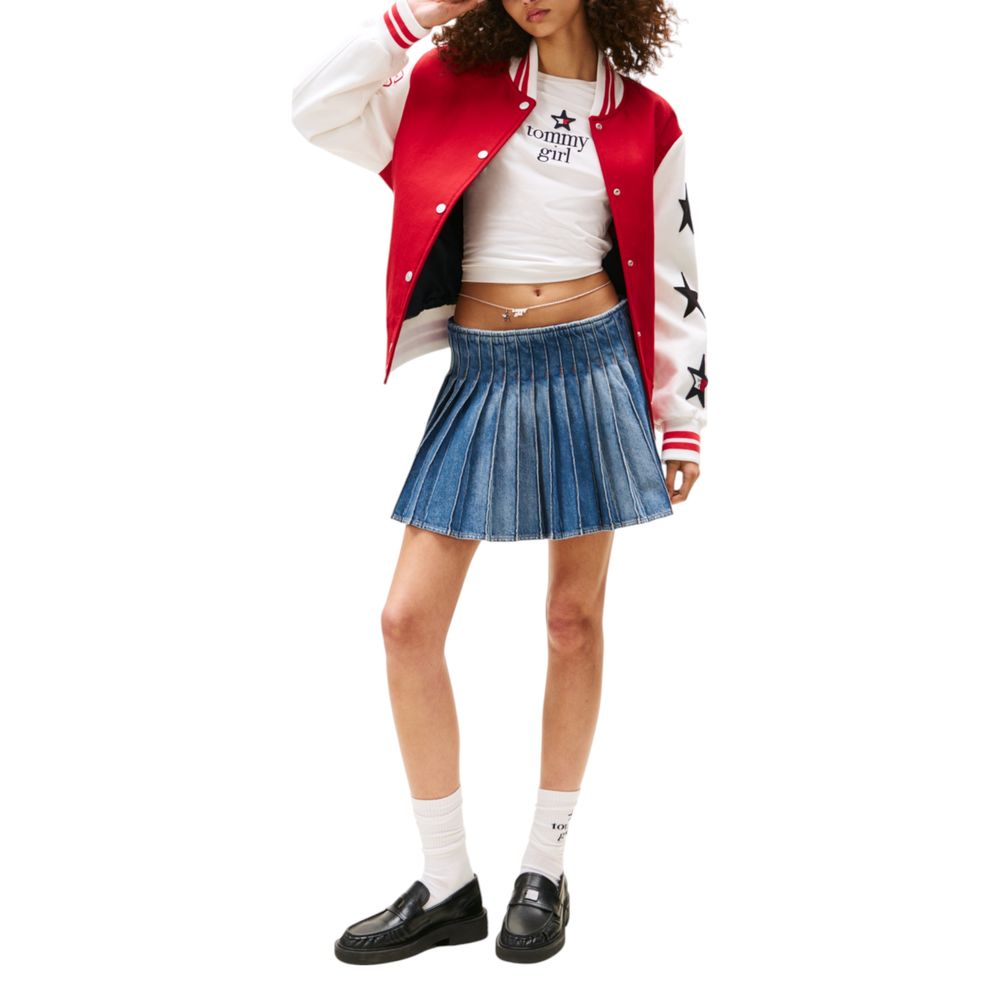 Young woman wearing a red jacket with white stars, denim skirt, black shoes, and a white t-shirt