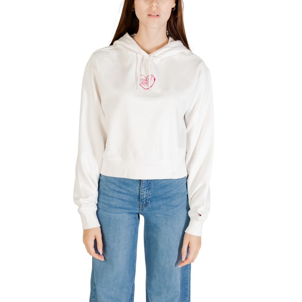 Woman wearing white hoodie with pink heart logo on front