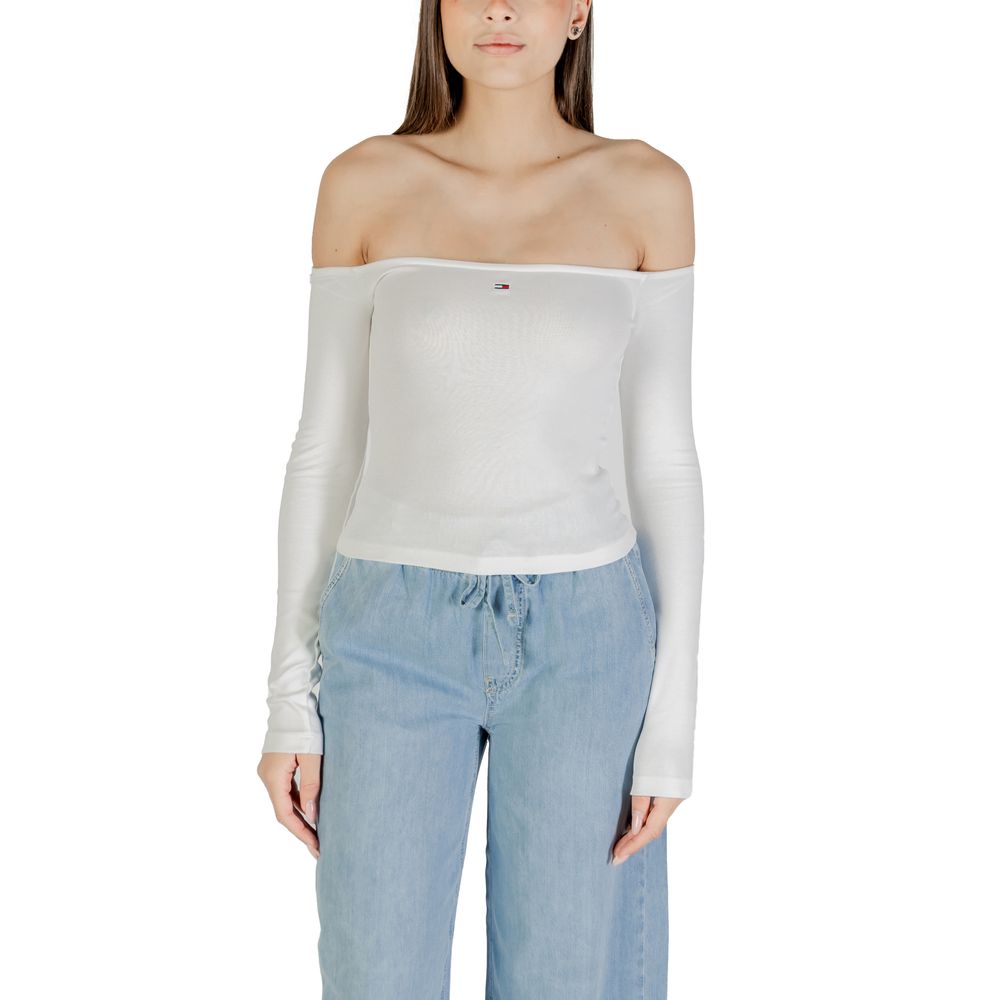 Woman wearing white long sleeve top and blue jeans