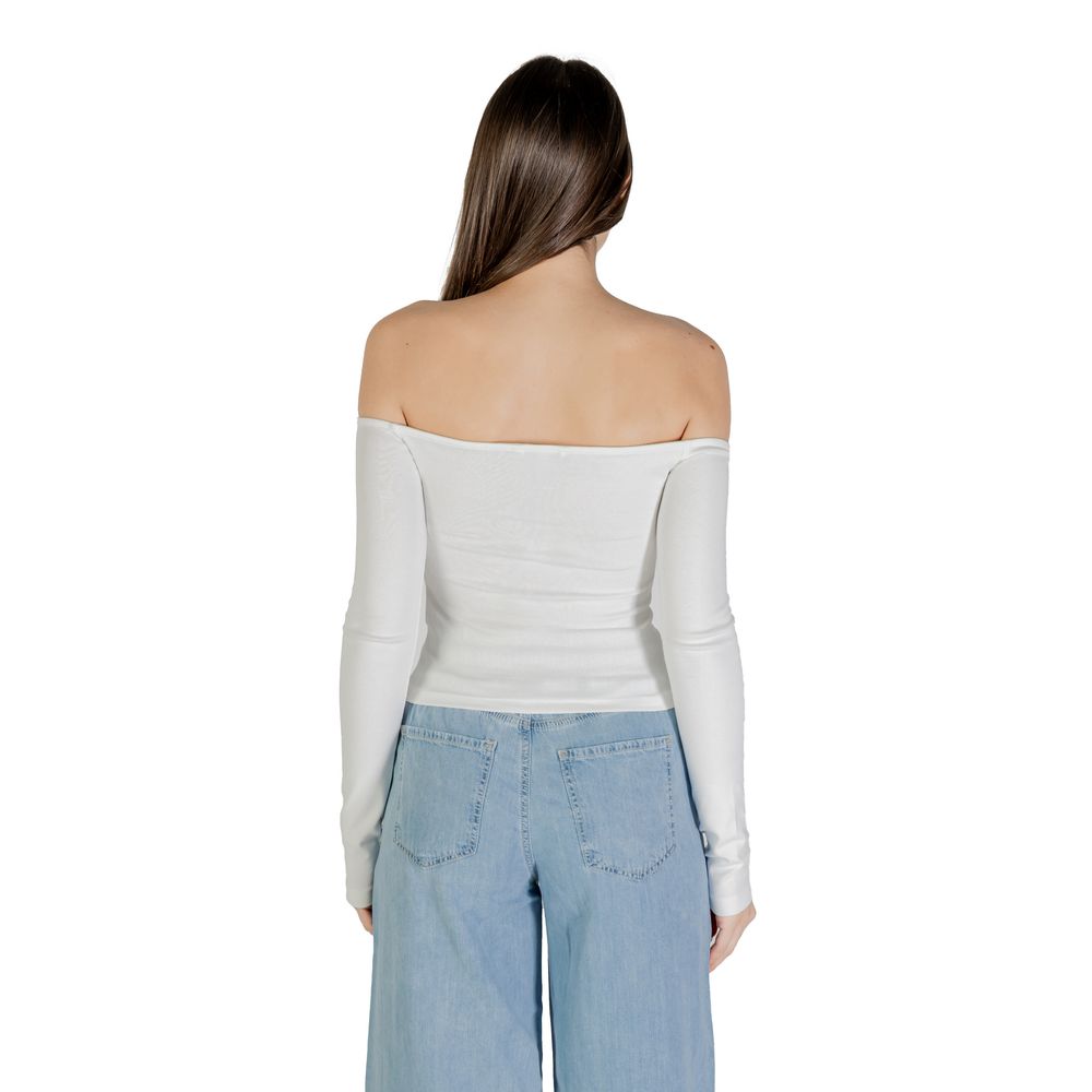 Woman wearing white tank top and blue jeans