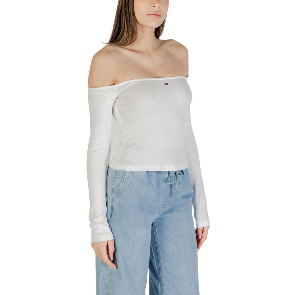 Woman wearing white off-the-shoulder top and blue jeans