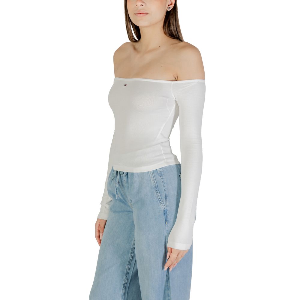 Woman wearing white tank top and blue jeans