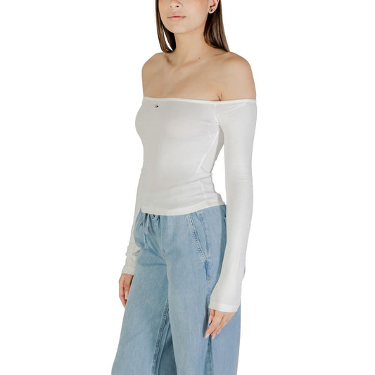 Woman wearing white tank top and blue jeans