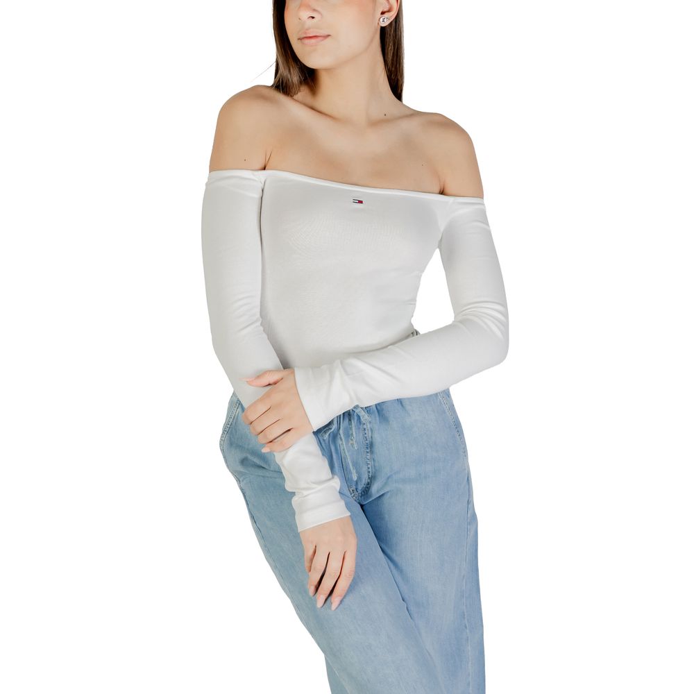 Woman wearing white long sleeve top and blue jeans