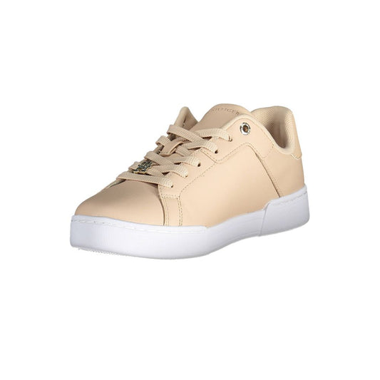 A tan leather women's sneaker with white laces and a low top, featuring the Tommy Hilfiger logo on the side