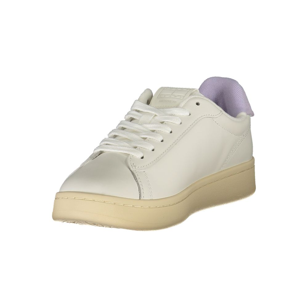 A white women's sneaker with a purple lace tie, featuring a low-top design and a flat sole