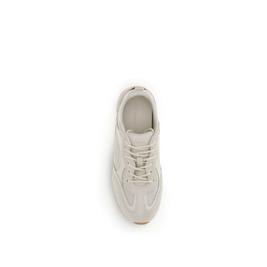 A pair of beige sneakers with white laces, made of polyester material