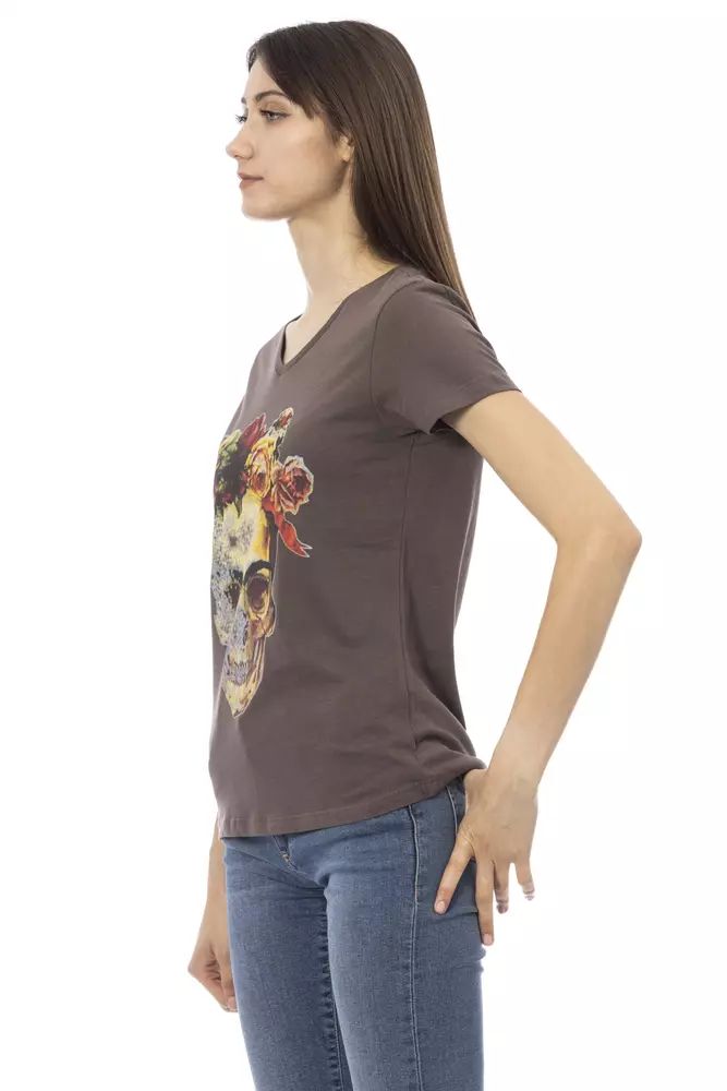 A brown cotton t-shirt with a graphic print on the front, worn by a woman standing against a white background