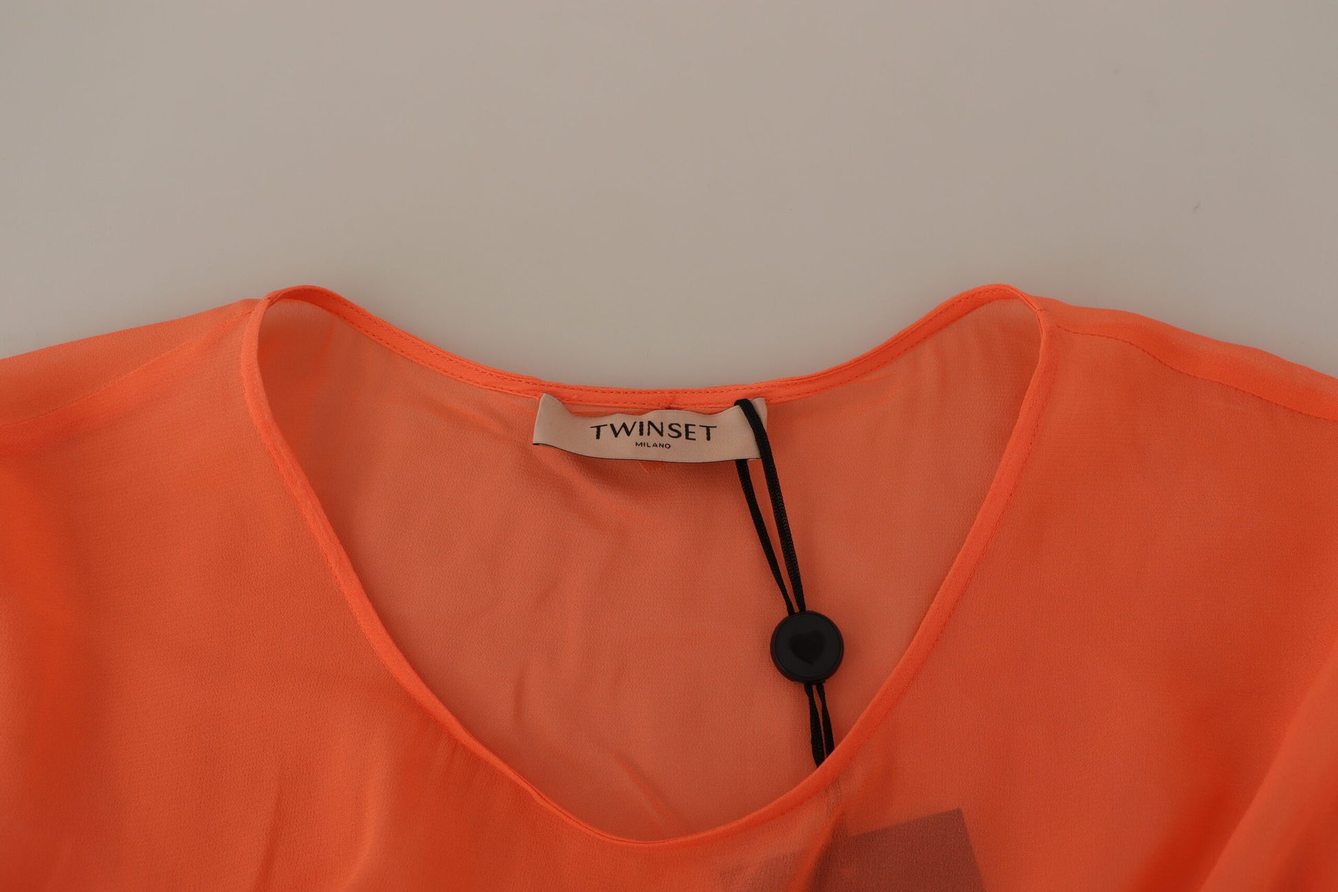 Orange sleeveless shirt on hanger