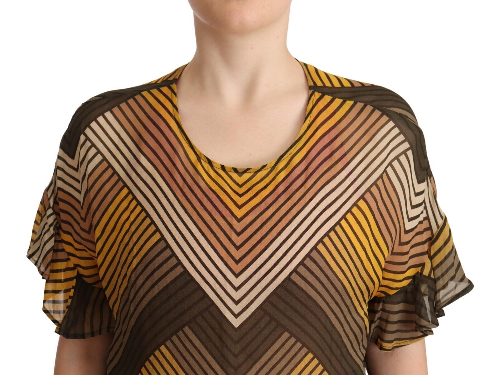 A person wearing a colorful top with geometric patterns in shades of yellow, brown, and white
