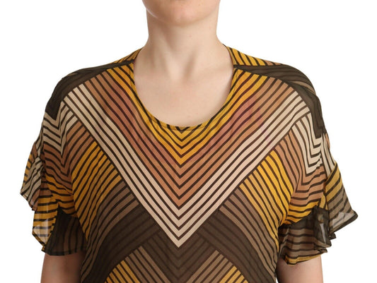 A person wearing a colorful top with geometric patterns in shades of yellow, brown, and white