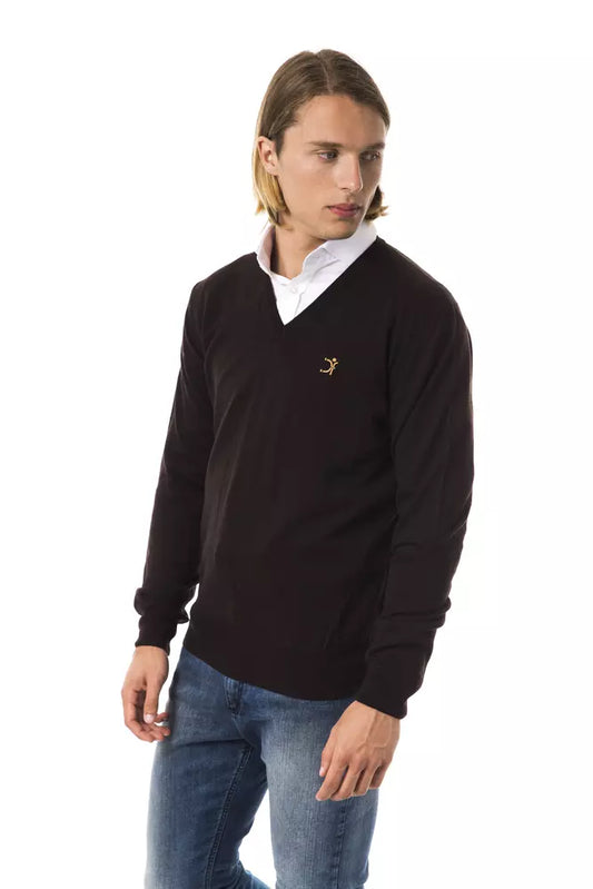 Man wearing dark sweater with logo on left chest