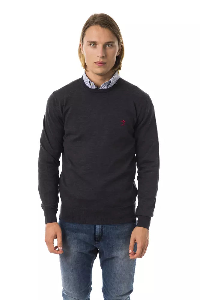Man wearing dark sweater with red logo on chest